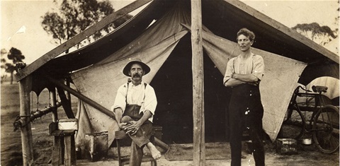 two men outside an old tent