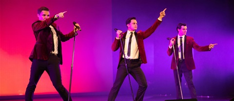 three men performing on stage